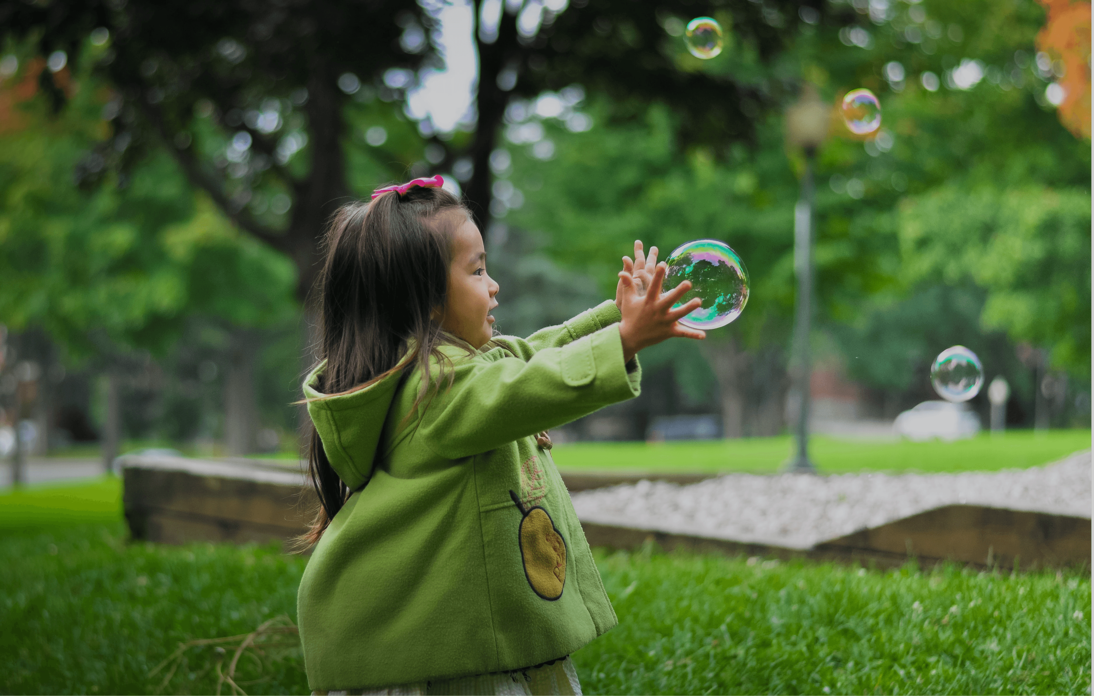 Enfant jouant avec une bulle de savon en extérieur