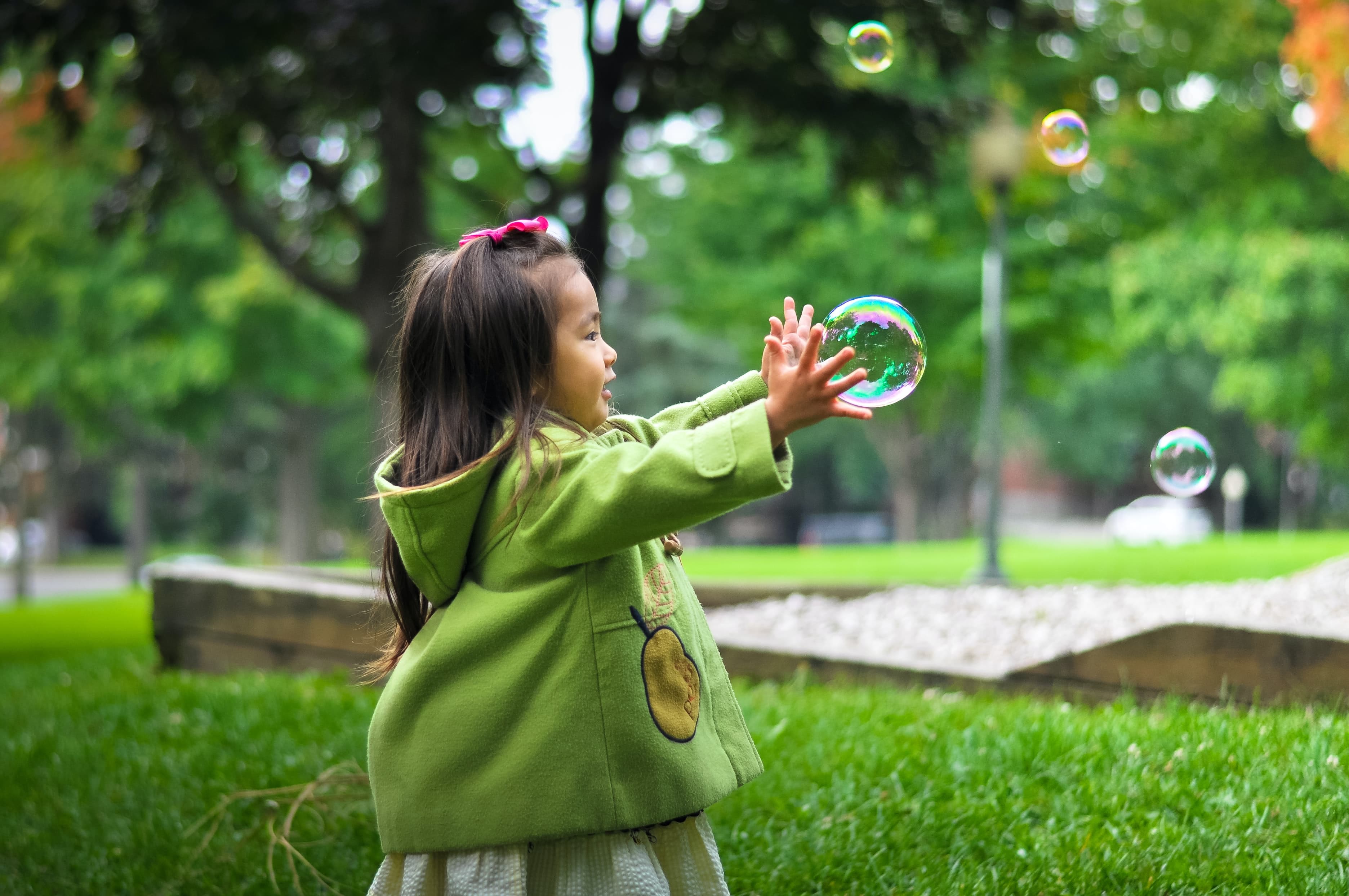 Enfant jouant avec une bulle de savon en extérieur